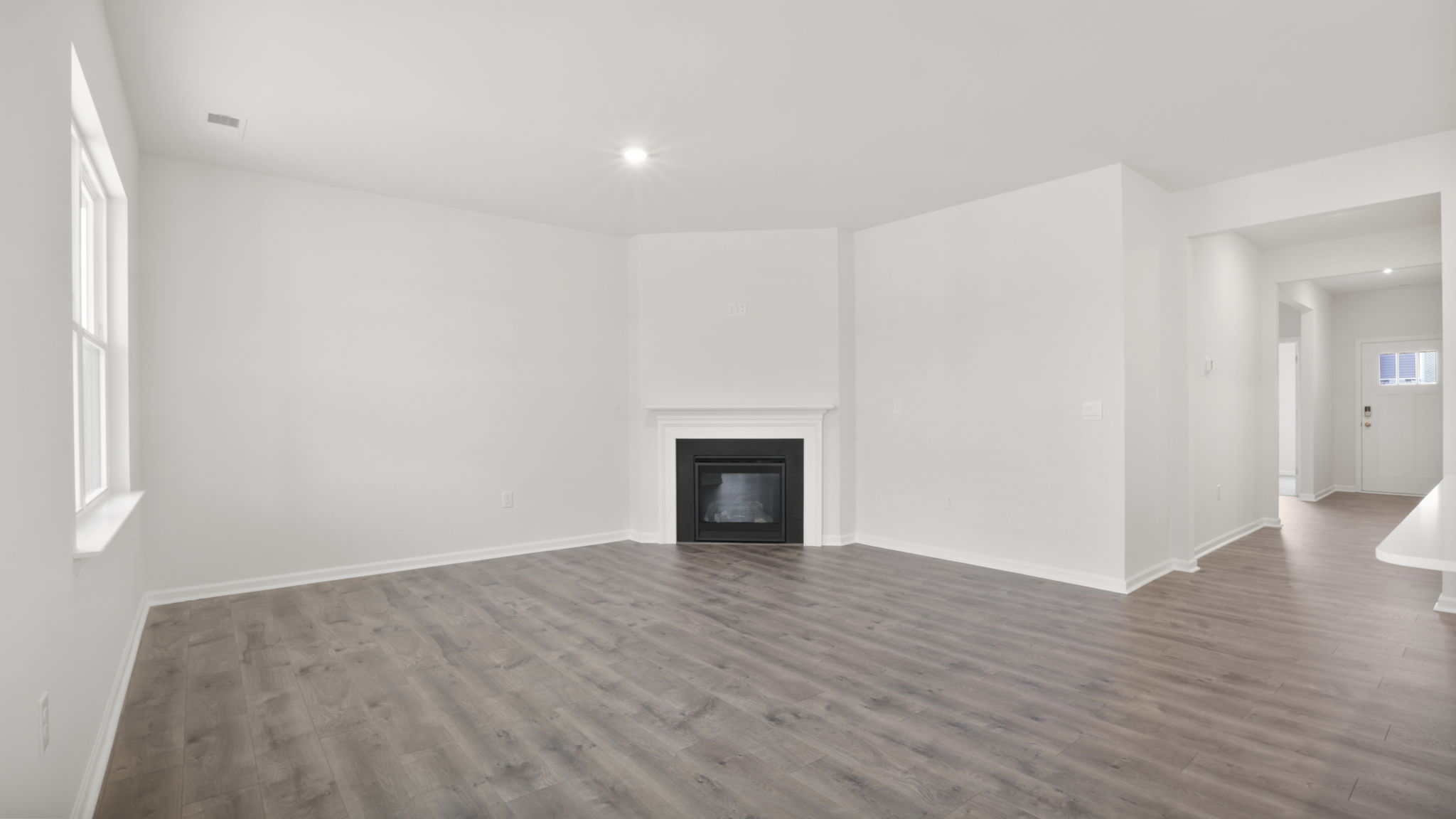 Family room with large windows and gas log fireplace.