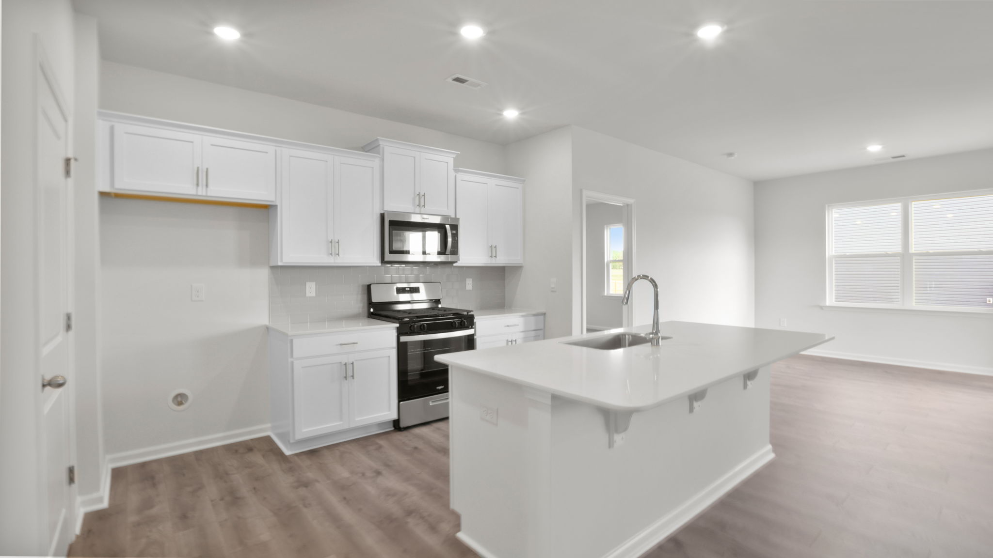 Kitchen has recessed lighting and overlooks dining and family areas.
