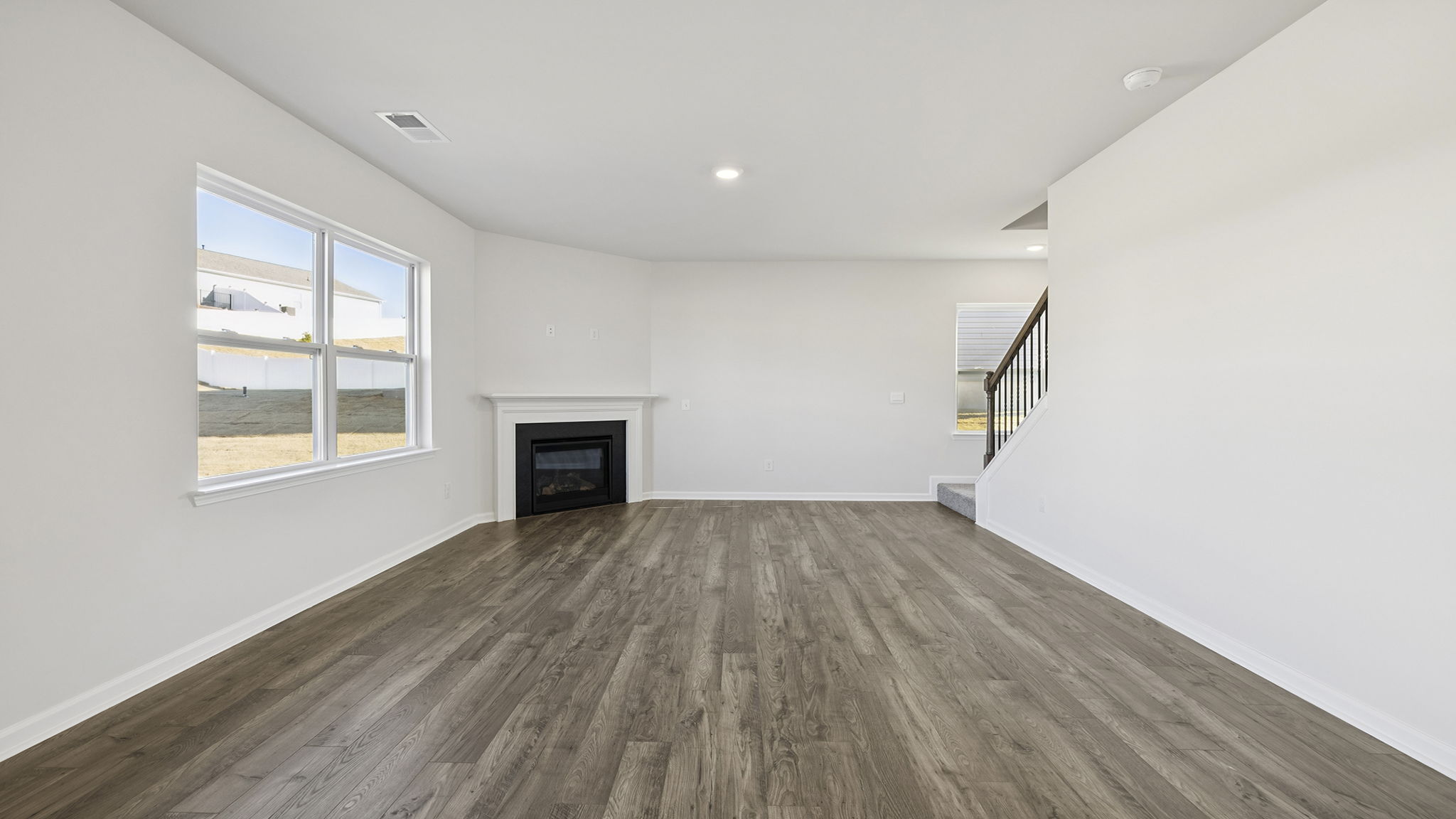 Family room with fireplace and view of stairs.