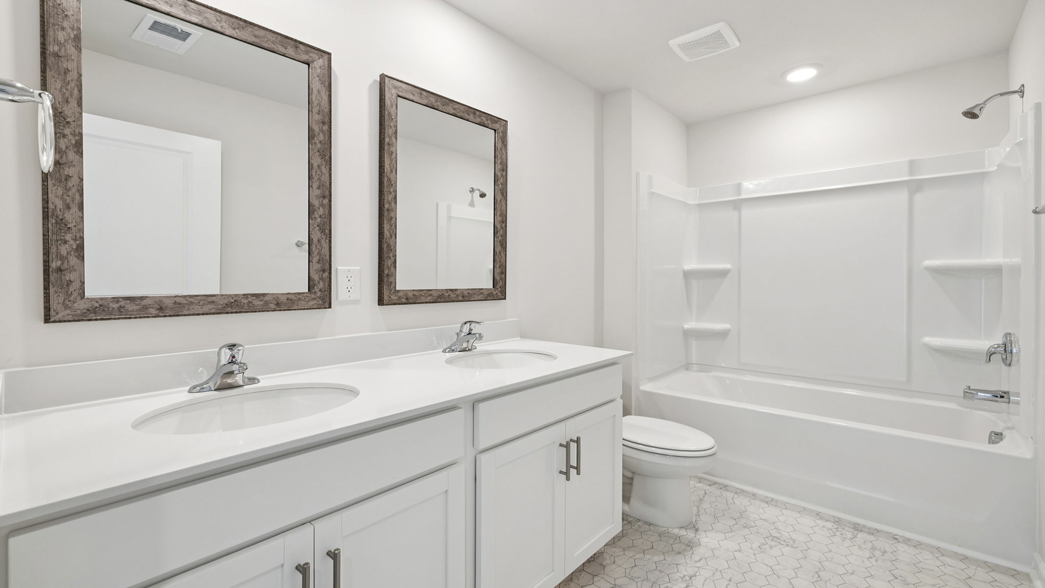 Hall bathroom with dual sink vanity and combination shower / tub.