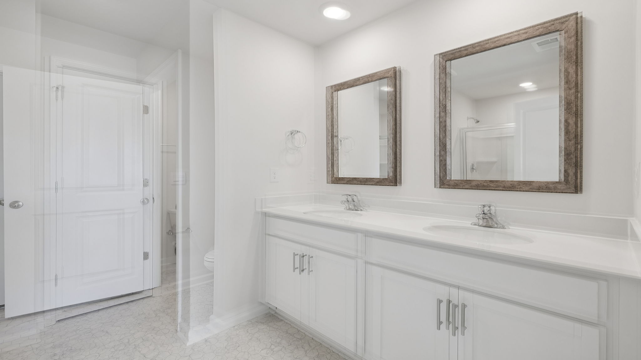 Primary bathroom with double sink vanity and walk in closet.