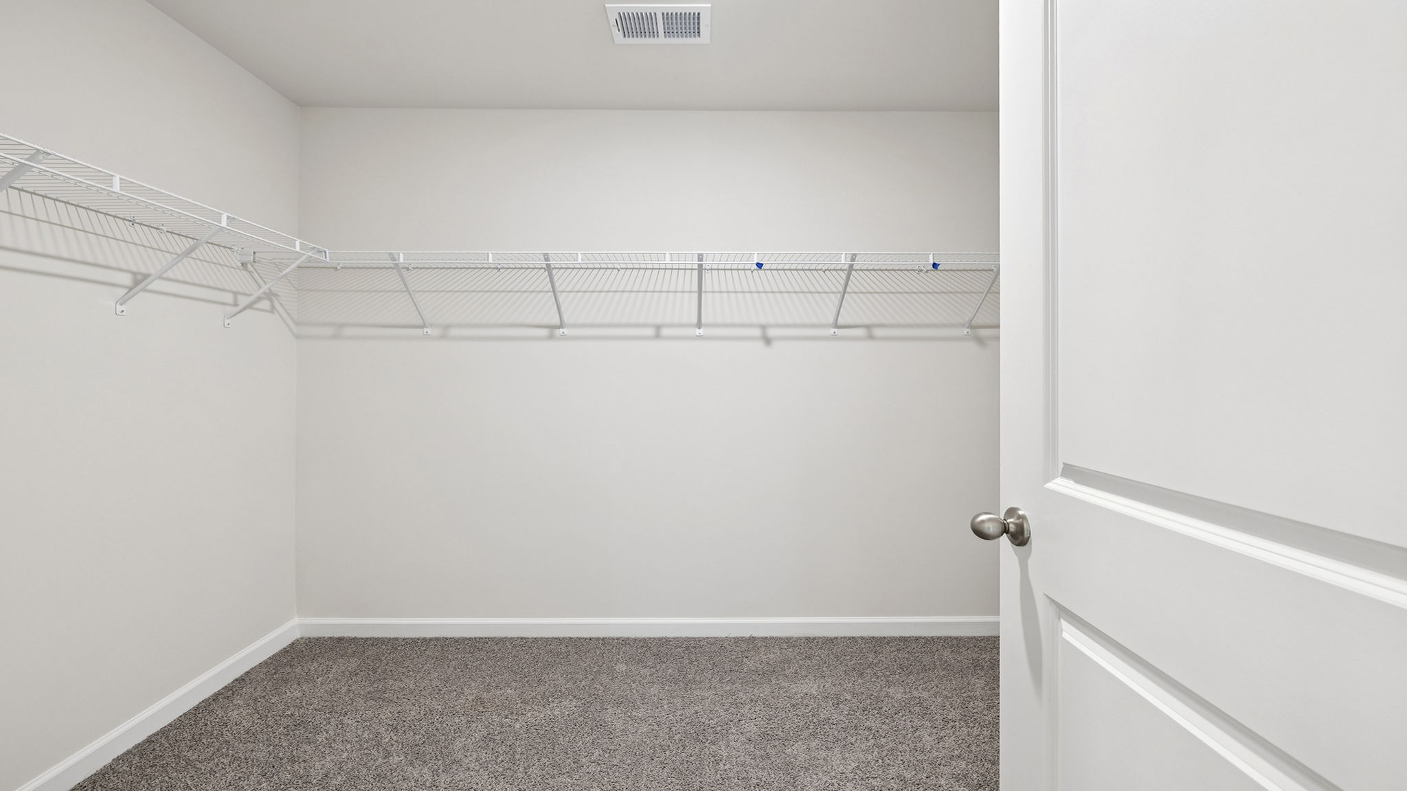 Primary bedroom walk-in closet with shelving.