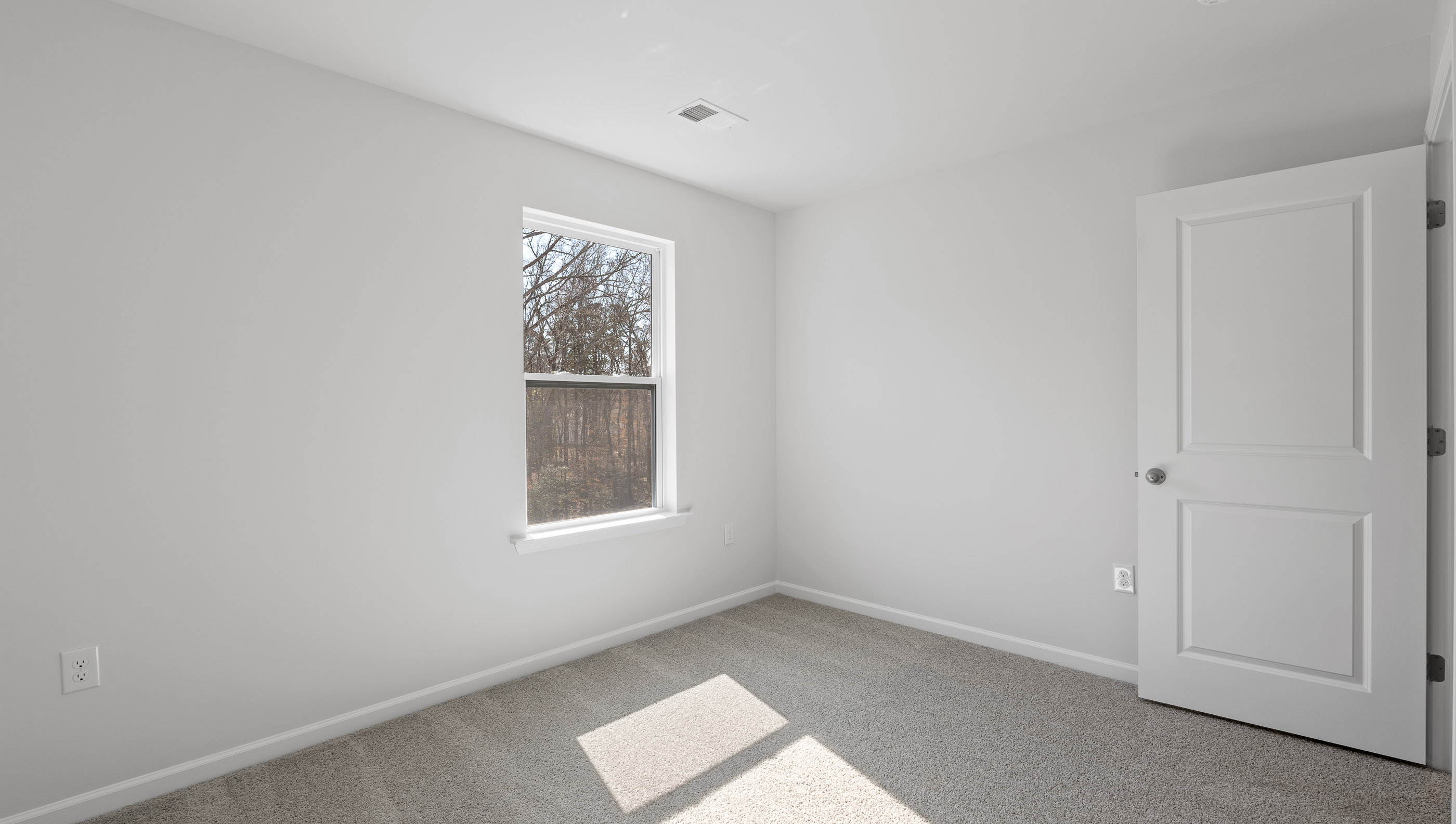 Bedroom with carpet and windows.