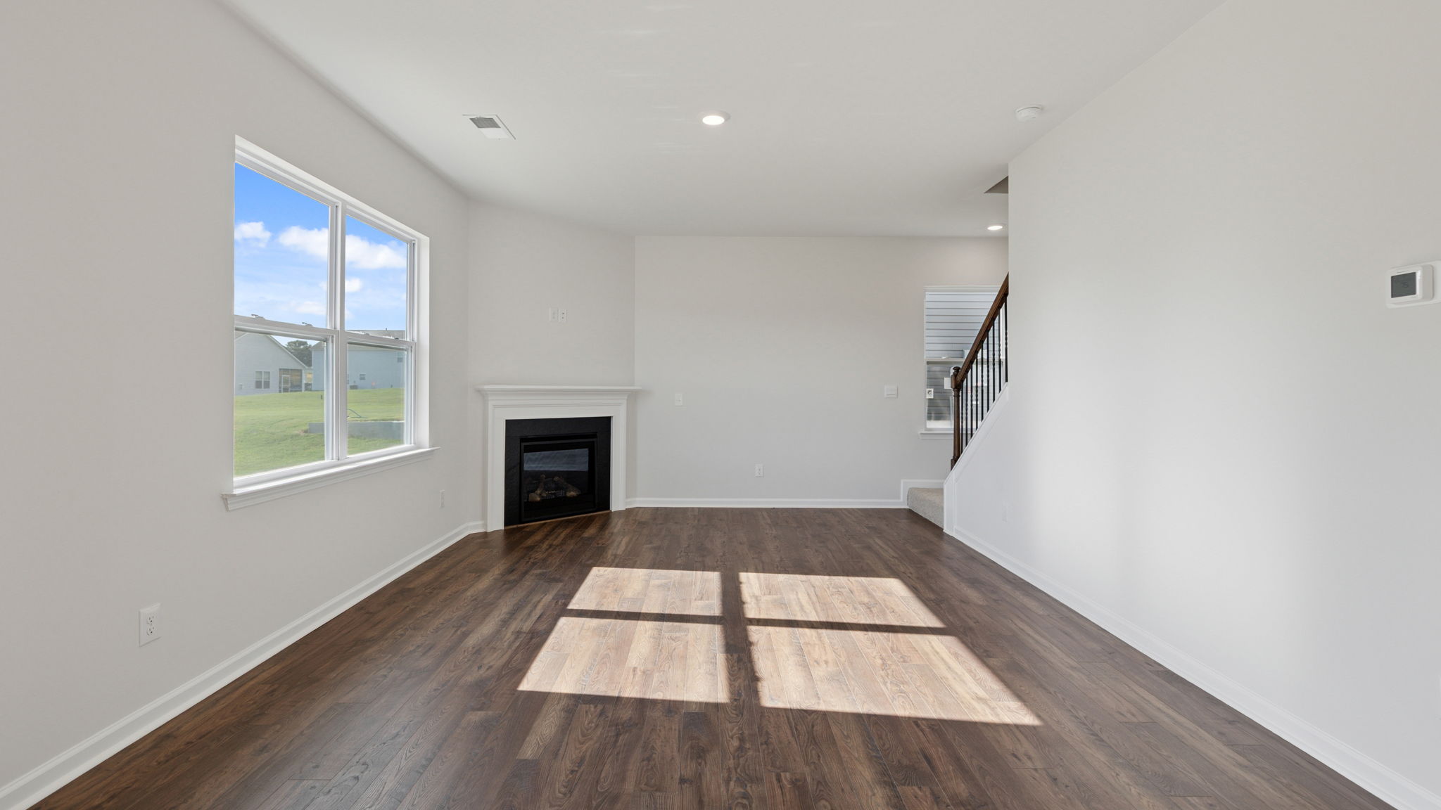 Family room with fireplace and view of stairs.