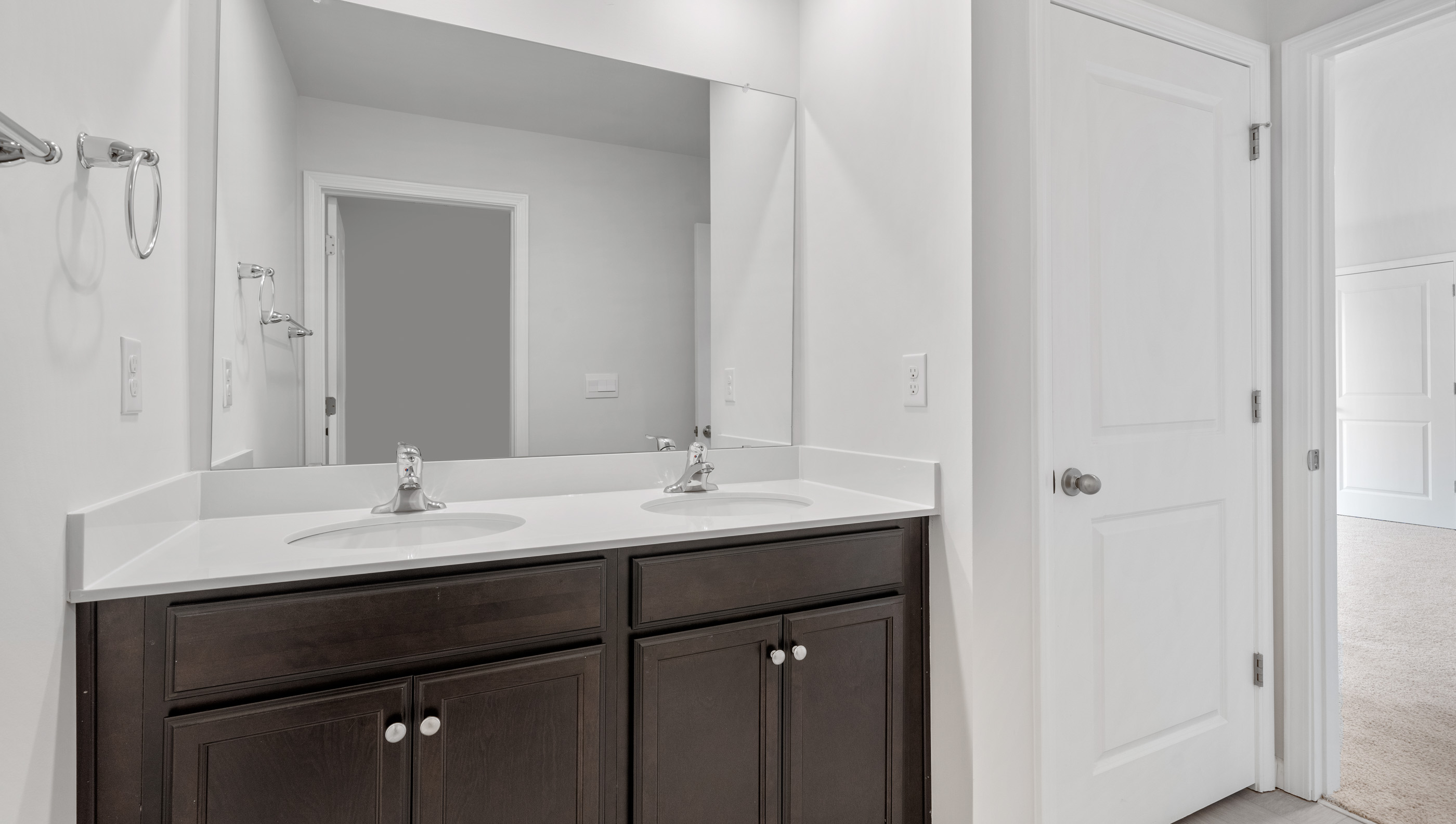 Hall bathroom with dual sink vanity separate from shower area.