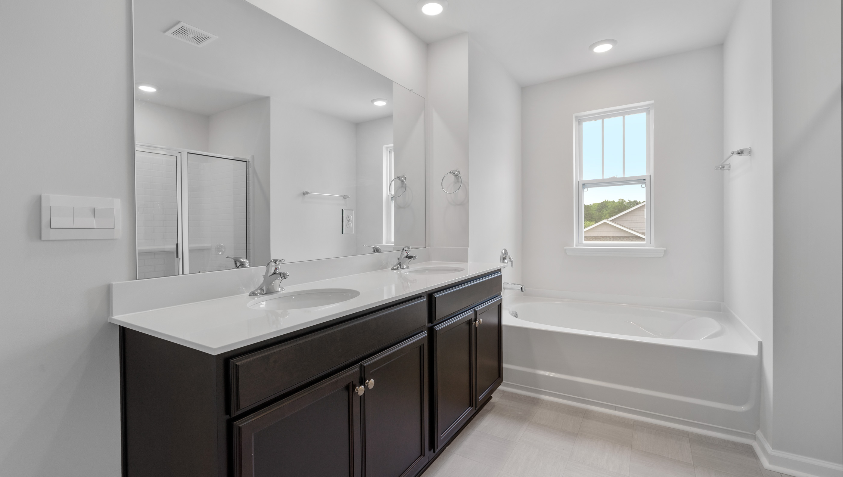 Primary bathroom with dual sink vanity and garden tub.