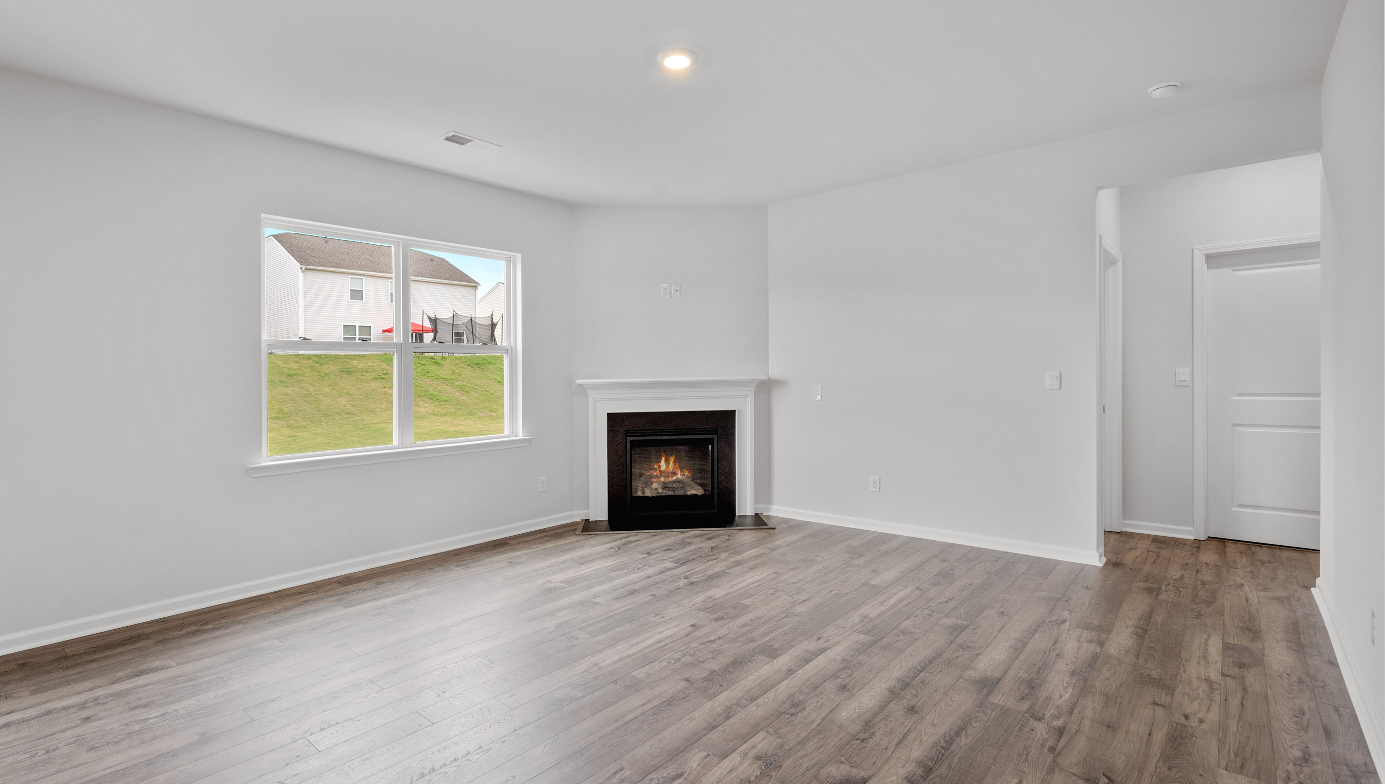 View of the family room with lots of windows and gas log fireplace.