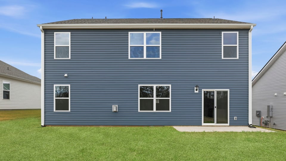 Back exterior with patio and large backyard.