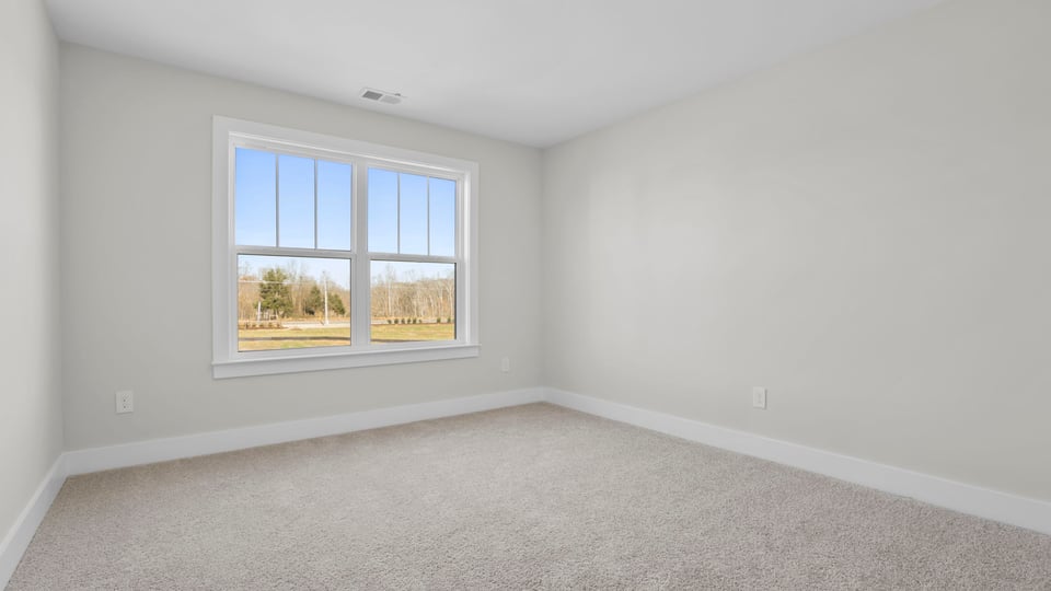 Bedroom with carpet and window.