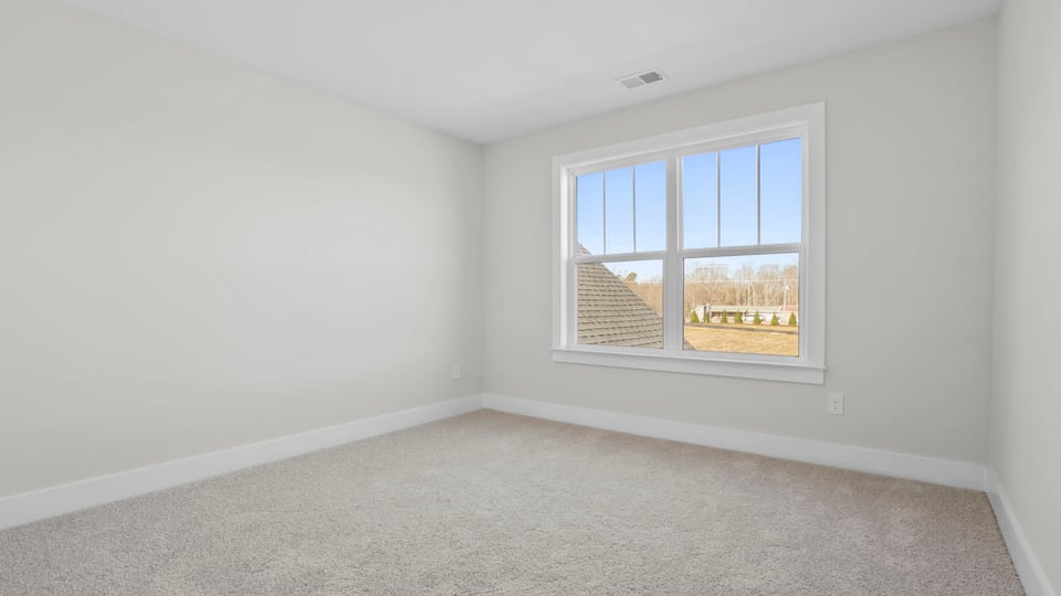 Bedroom with carpet and window.