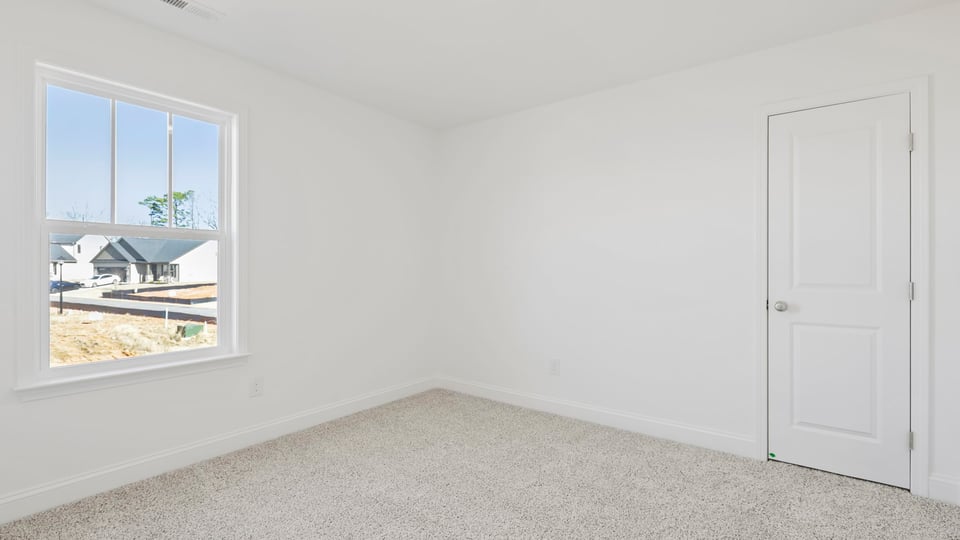 Bedroom with carpet and window.