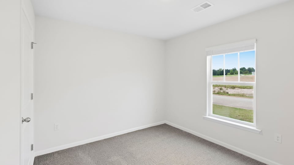 Bedroom with carpet and windows.