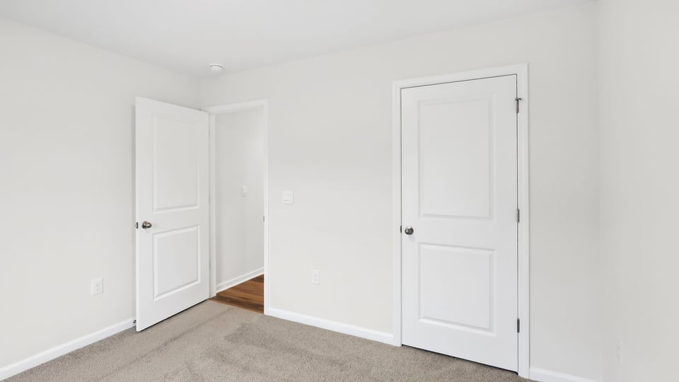 Bedroom with carpet and windows.