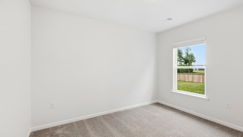 Bedroom with carpet and windows.