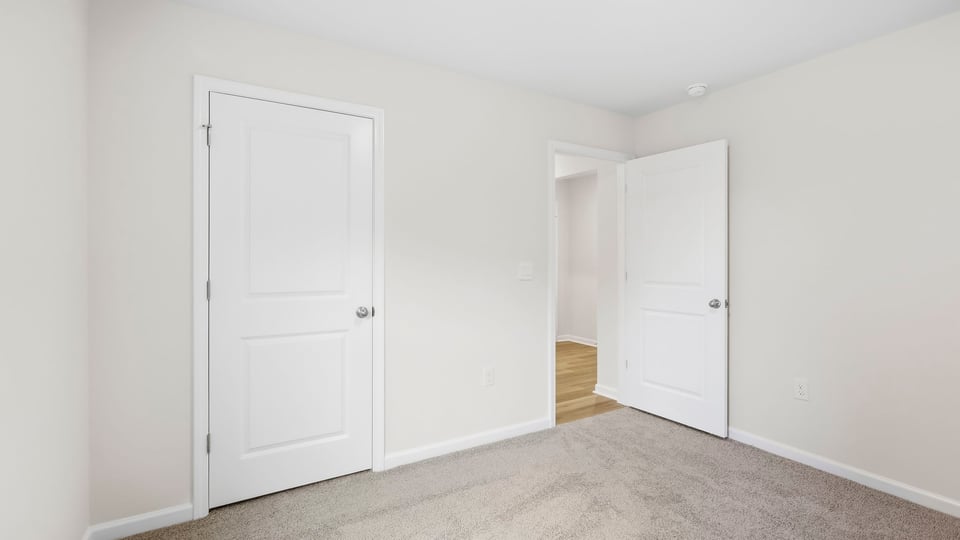 Bedroom with carpet and windows.