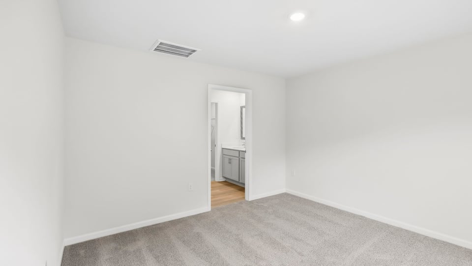 Bedroom with carpet and windows.