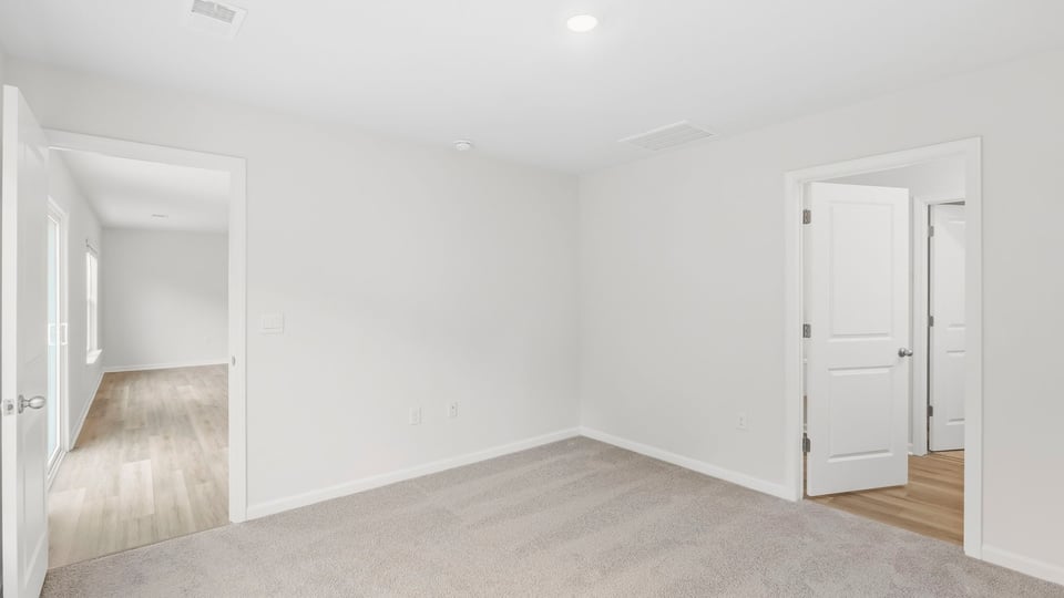 Bedroom with carpet and windows.