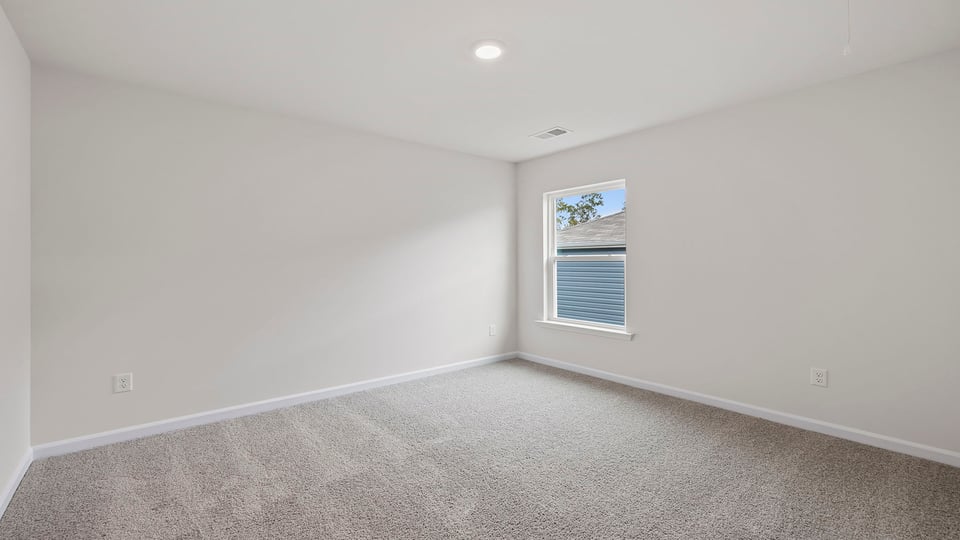Bedroom with carpet and window.