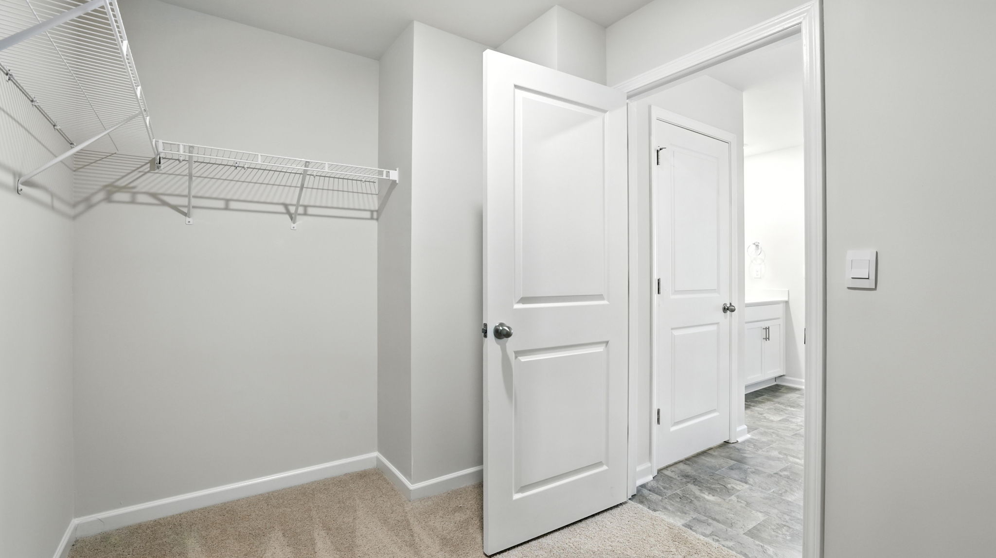 Walk in closet with hanging shelves.