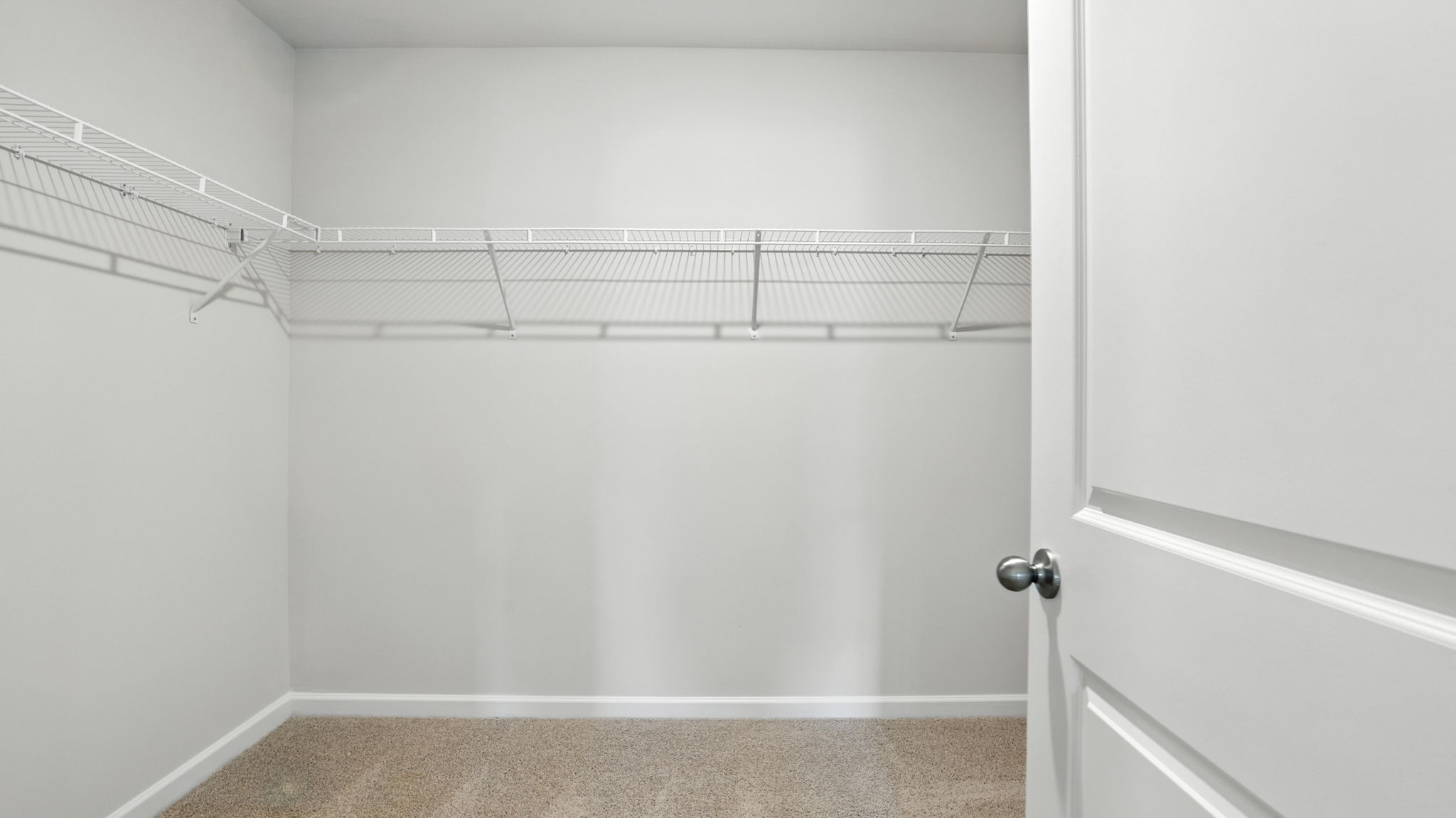Walk in closet with hanging shelves.