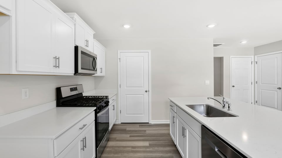 Kitchen and island with stainless steel appliances.