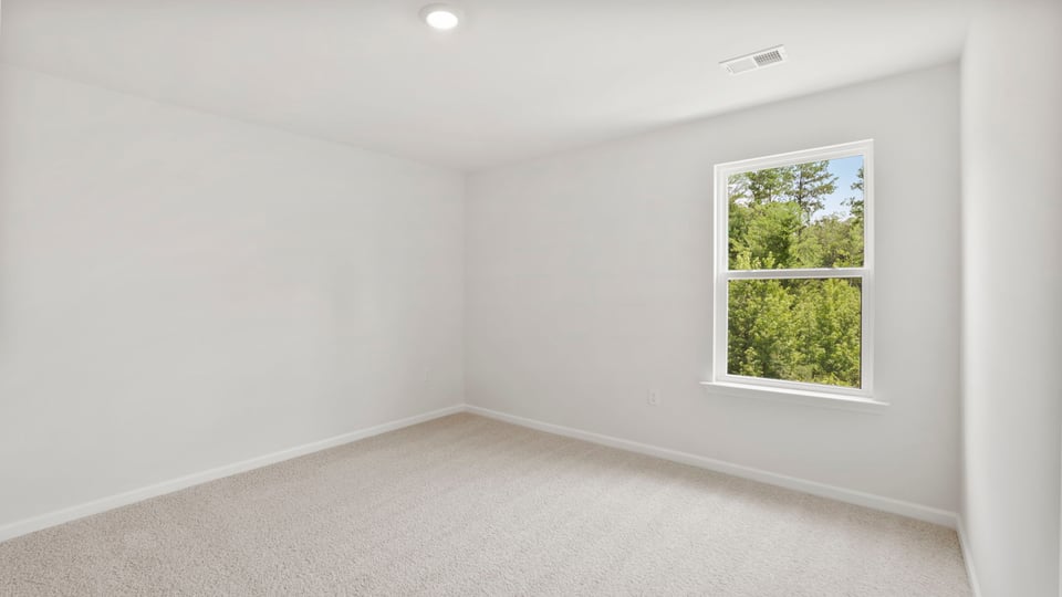 Bedroom with carpet and window.