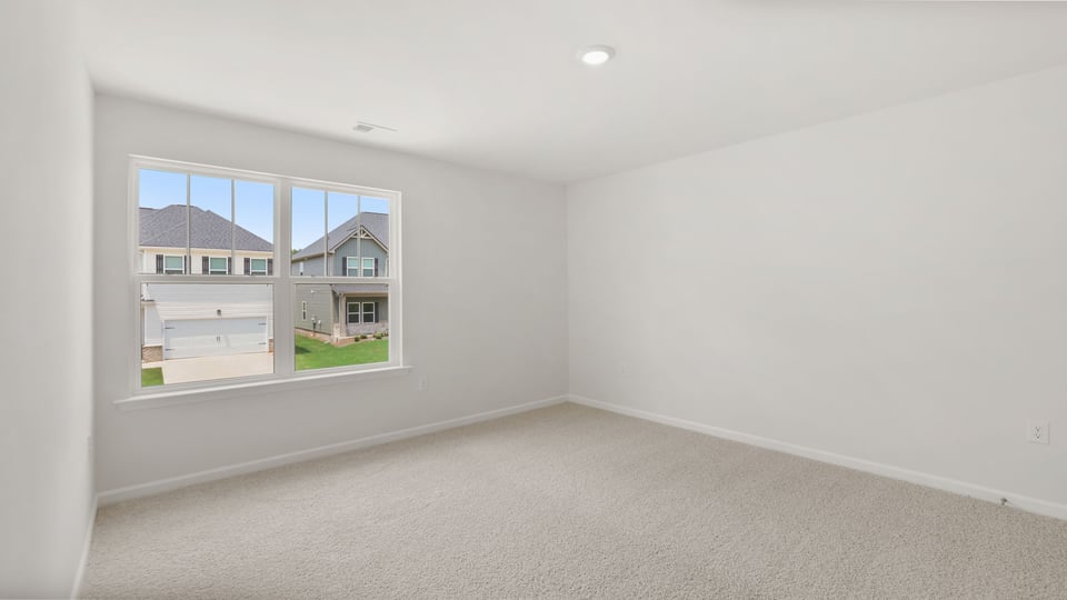 Bedroom with carpet and window.