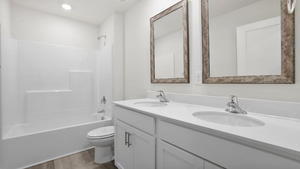 Bathroom with double vanity sink and bathtub.