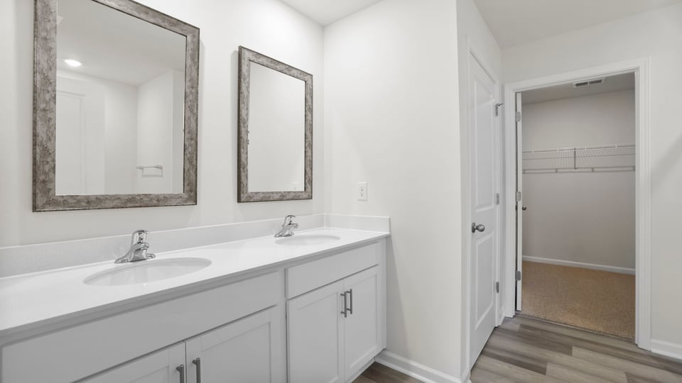 Bathroom with double vanity sink and walk in closet.