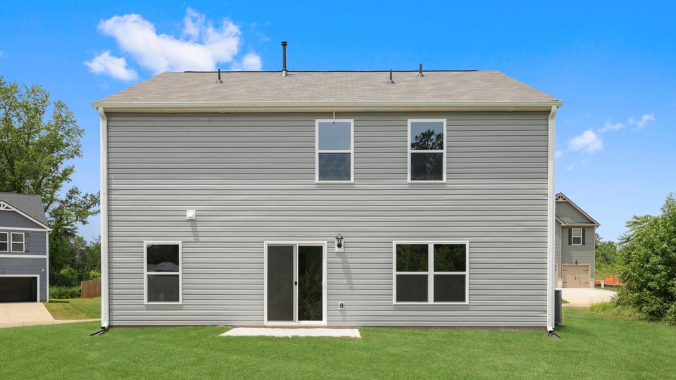 Back exterior of home with large backyard.
