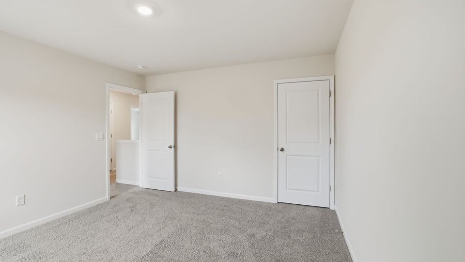 Bedroom with carpet and windows.