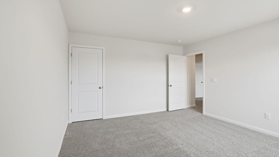 Bedroom with carpet and windows.