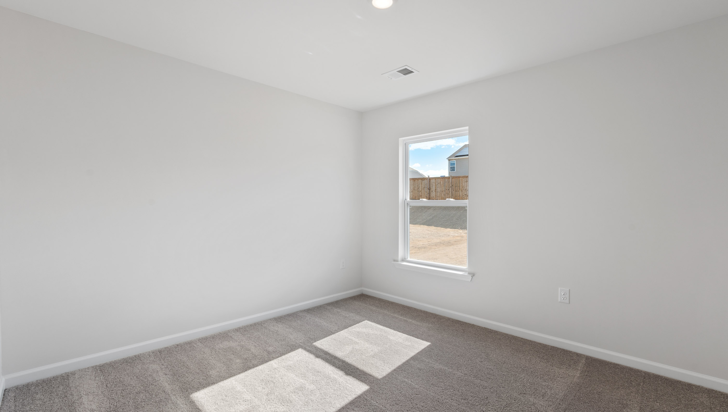 Bedroom with carpet and windows.
