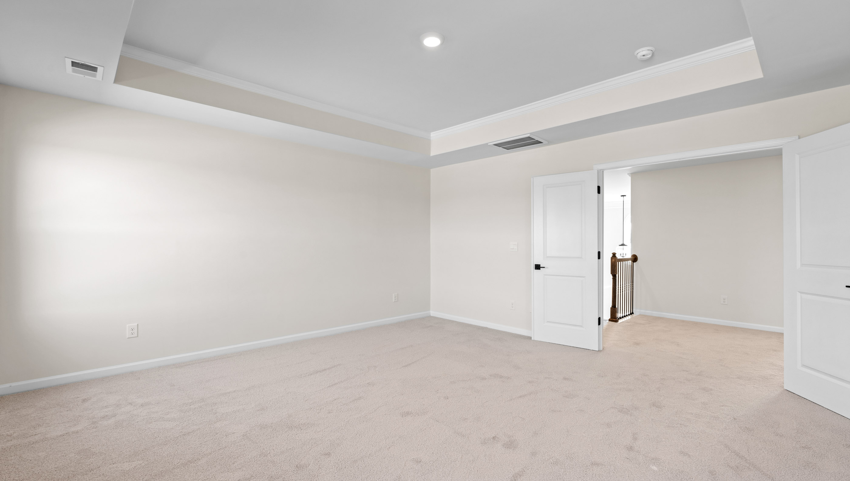 Primary bedroom with carpet and windows.