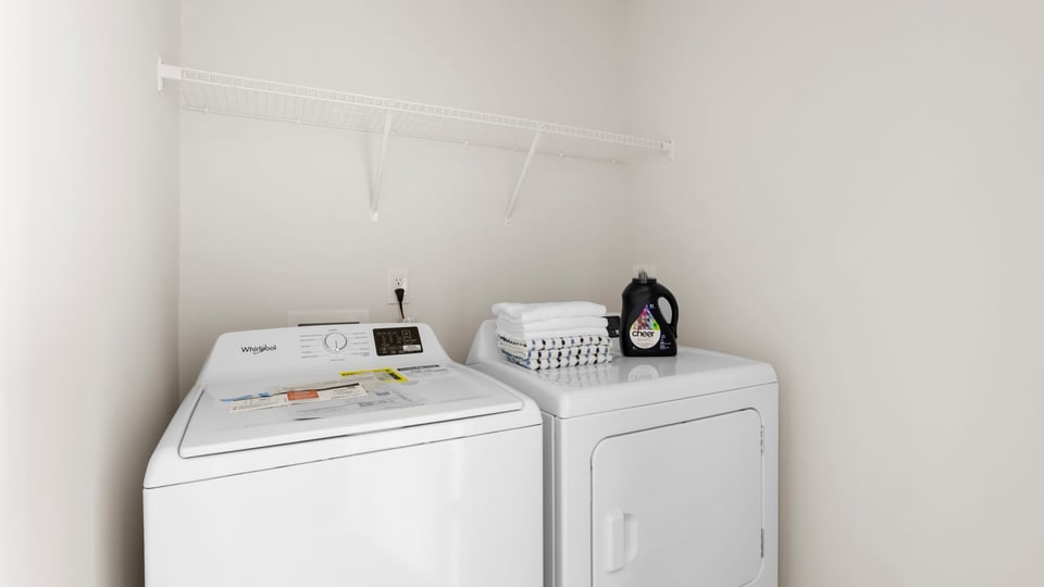 Laundry room with hanging storage racks.