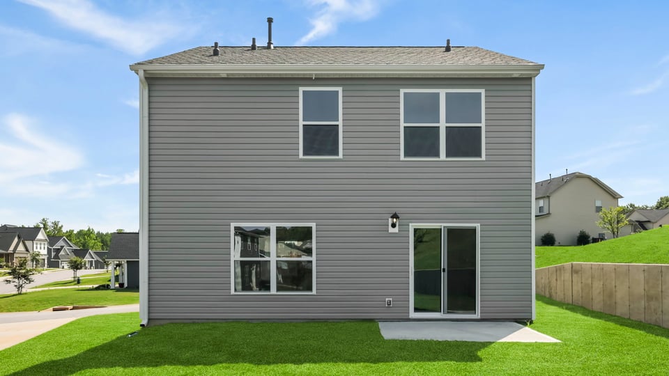 Back exterior of home with large backyard.
