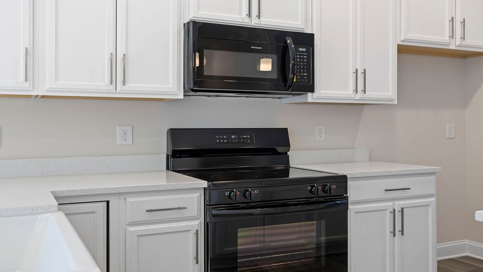 White cabinets and black appliances.