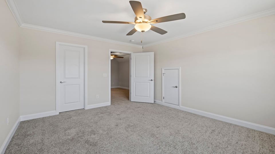 Bedroom with window, ceiling fan and carpet.