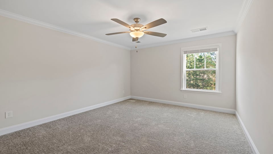 Bedroom with window, ceiling fan and carpet.