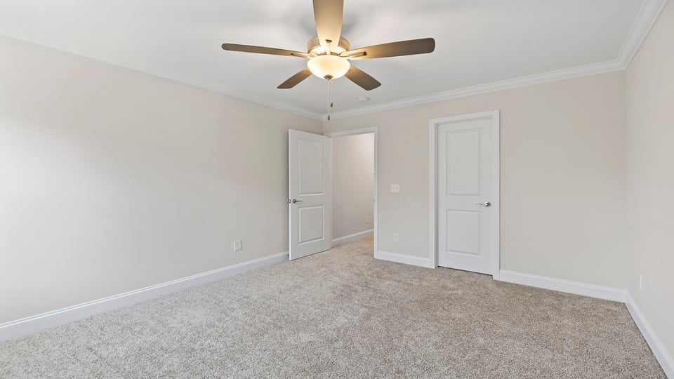 Bedroom with window, ceiling fan and carpet.