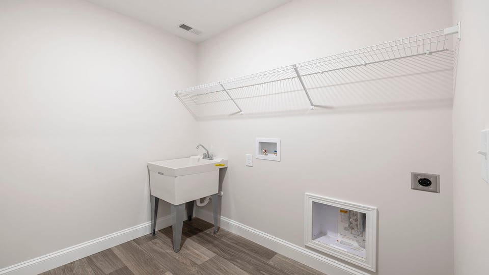 Laundry room with sink and shelving.