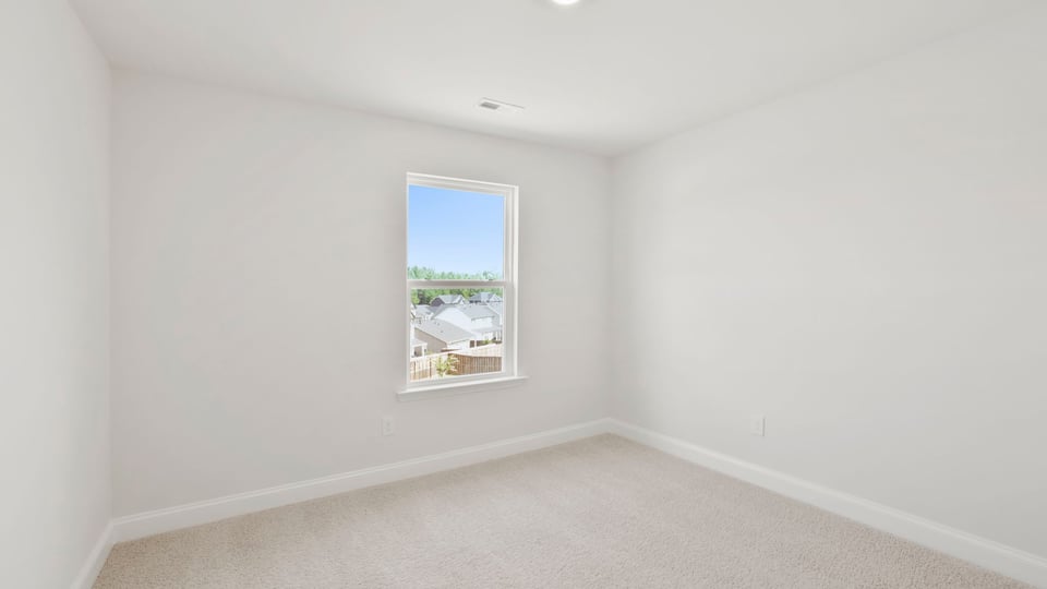Bedroom with carpet and window.