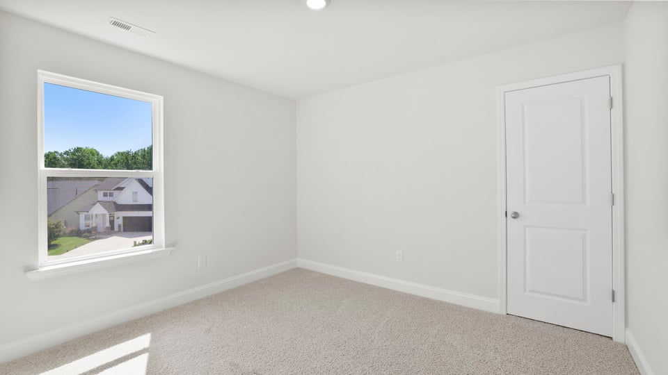 Bedroom with carpet and window.