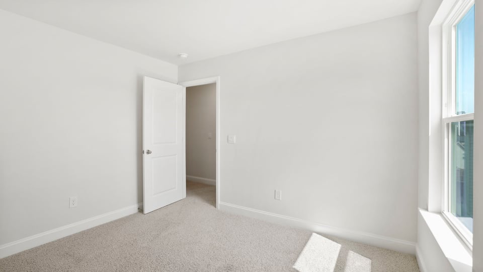 Bedroom with carpet and window.