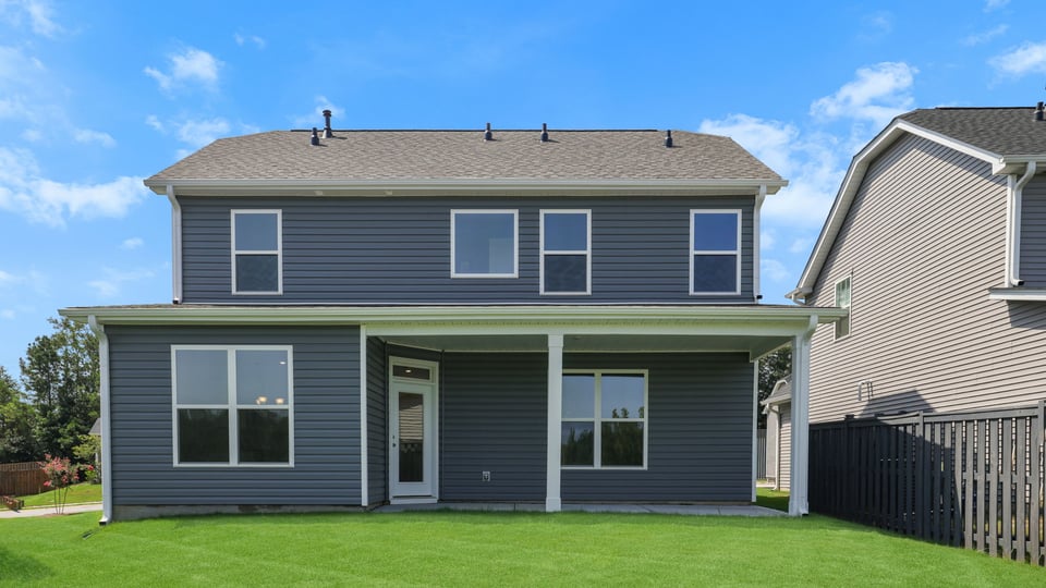 Back exterior of home with large backyard.