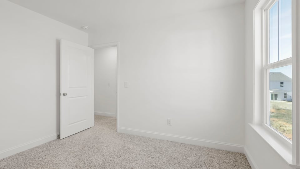 Bedroom with carpet and window.
