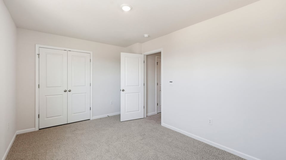 Bedroom with carpet and window.