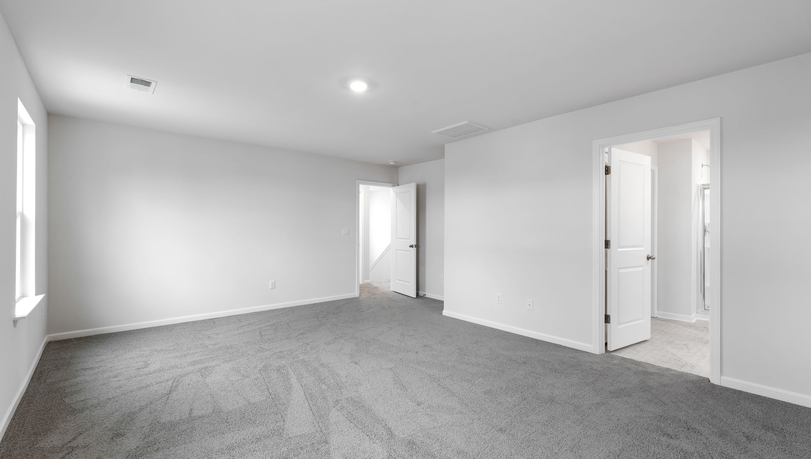 Bedroom with carpet and windows.