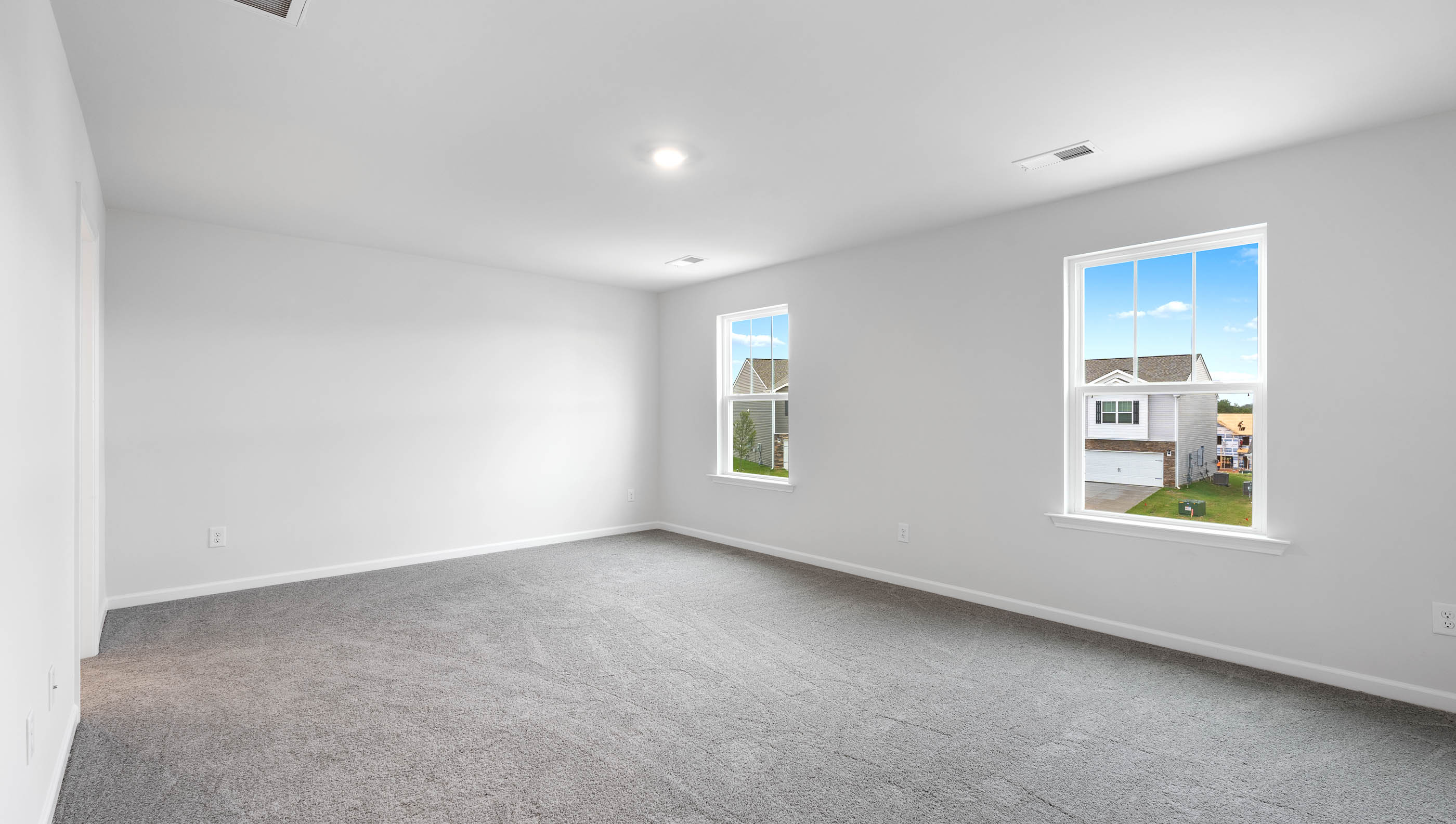 Bedroom with carpet and windows.