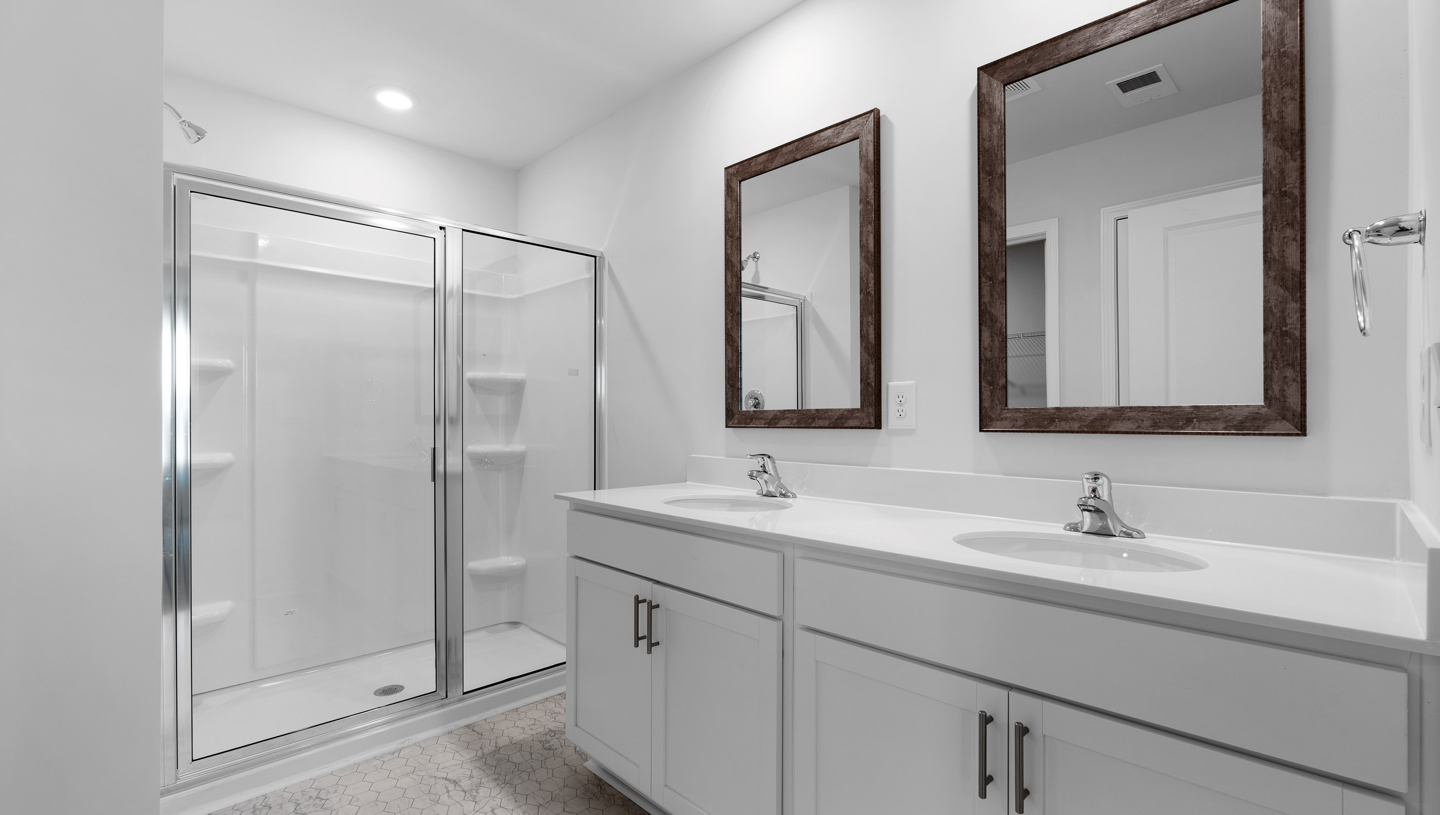 Bathroom with double vanity and walk in shower.